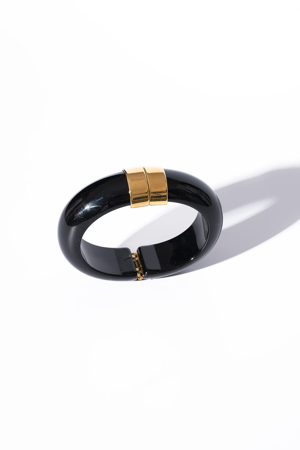 Μαύρο βραχιόλι με χρυσή λεπτομέρεια σε λευκό φόντο