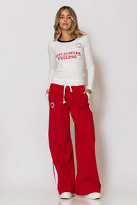 Κόκκινο φούτερ παντελόνι με λευκή ρίγα και τύπωμα logo “LESS SONDER FEELING”