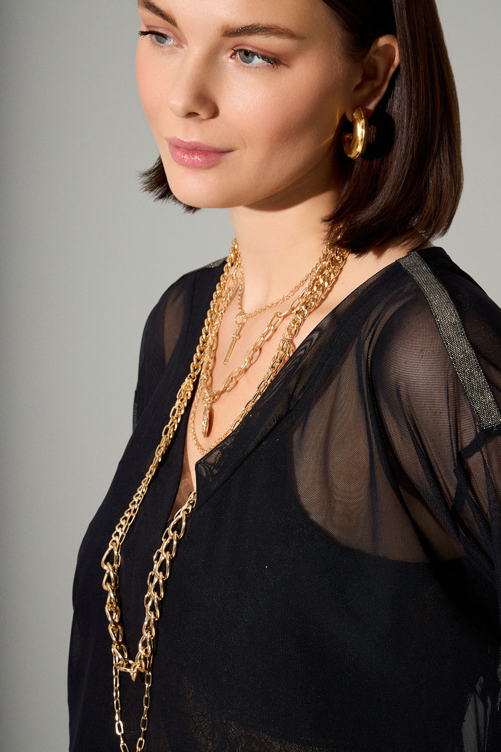 Μαύρη μπλούζα διαφάνεια με V λαιμόκοψη και χρυσό κέντημα φύλλων στην πλάτη.