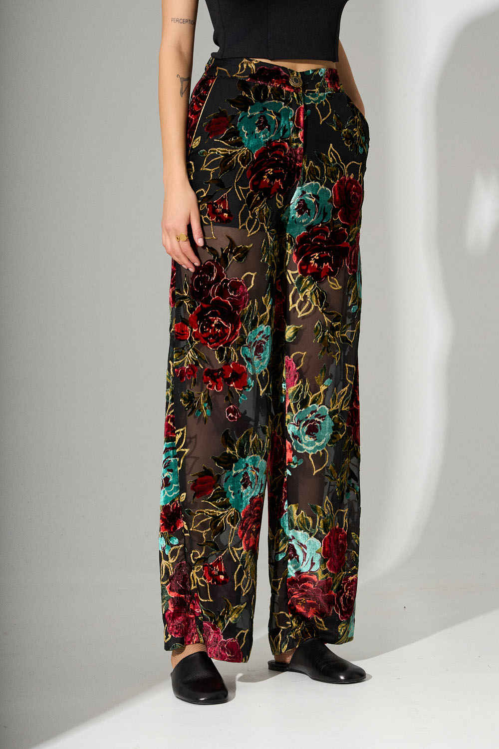 Μαύρη παντελόνα με διαφάνεια και βελούδινα λουλούδια σε κόκκινο και πράσινο με χρυσές λεπτομέρειες.