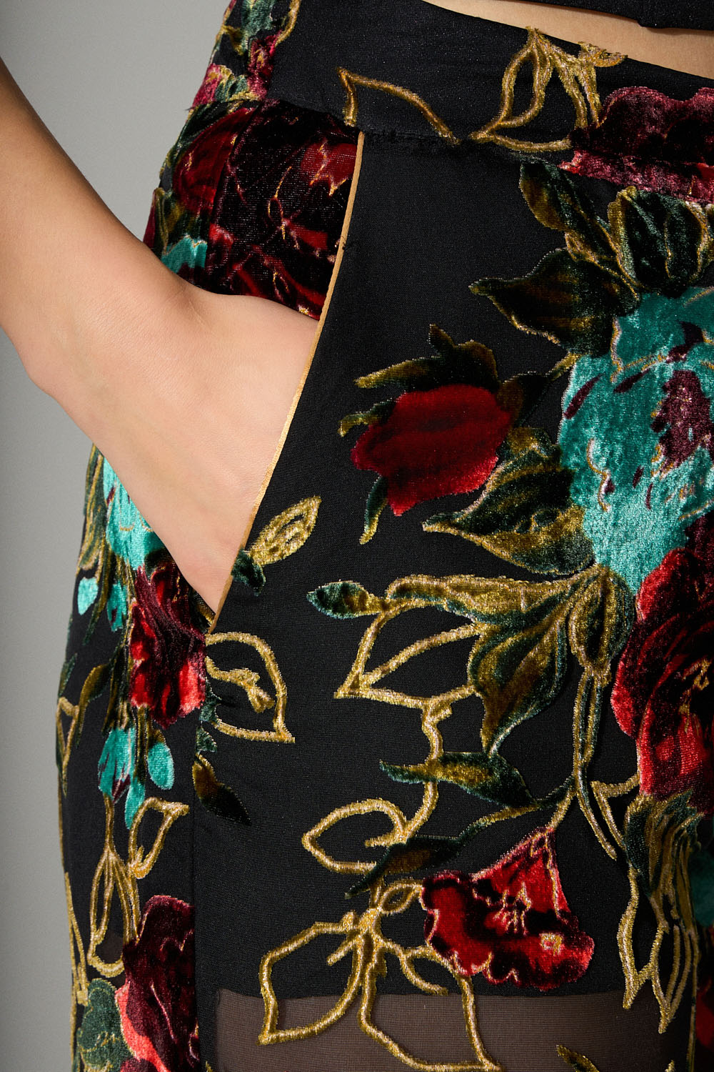 Μαύρη παντελόνα με διαφάνεια και βελούδινα λουλούδια σε κόκκινο και πράσινο με χρυσές λεπτομέρειες.
