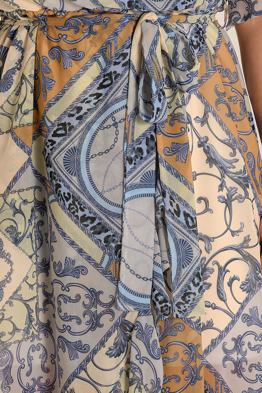Close-up of a belted muslin dress featuring intricate blue and gold patterns, ideal for boho-chic looks.