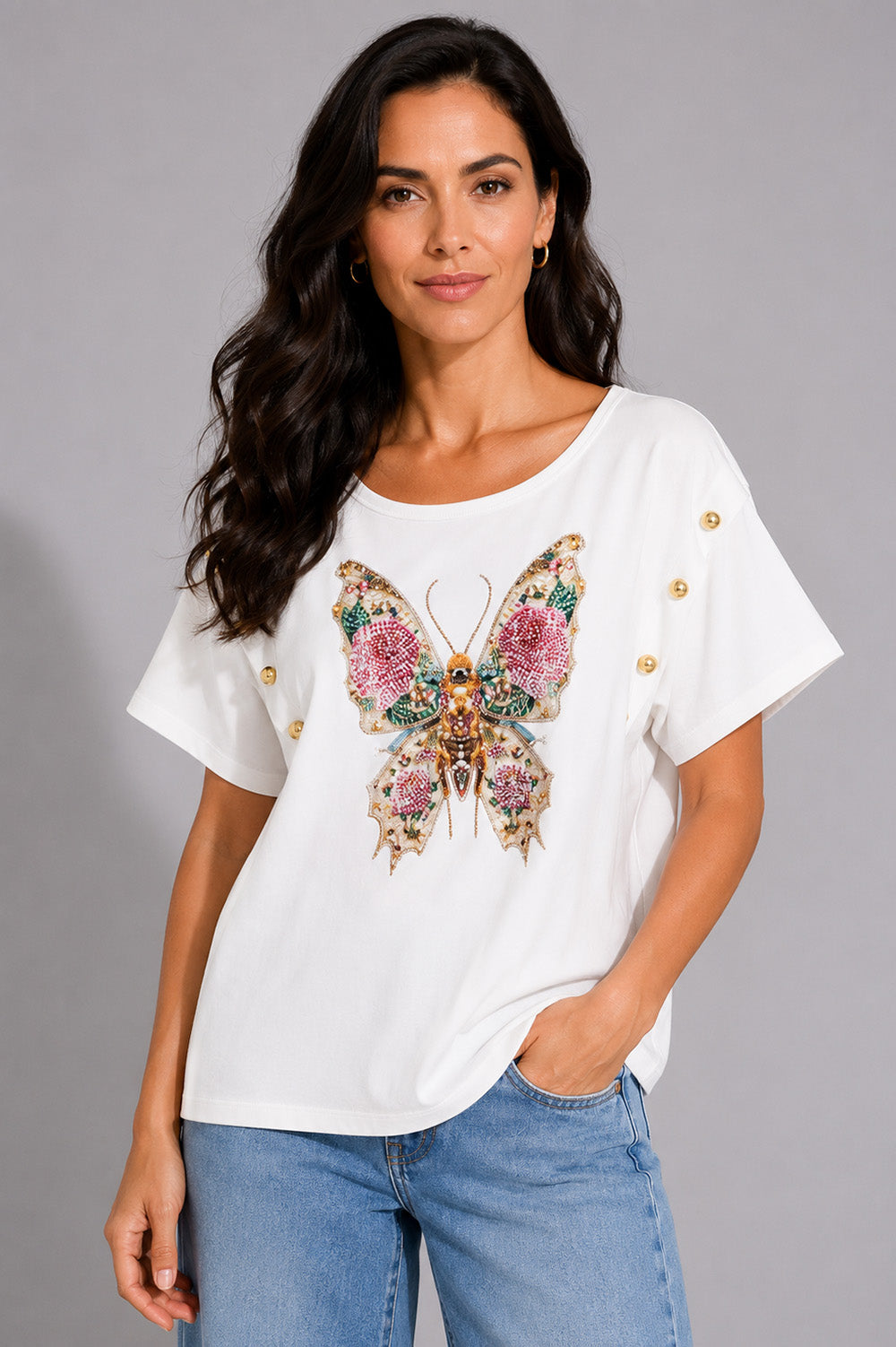 Λευκό γυναικείο T-shirt με διακοσμητική πεταλούδα από χάντρες και πέτρες και μεταλλικά κουμπιά στα μανίκια.