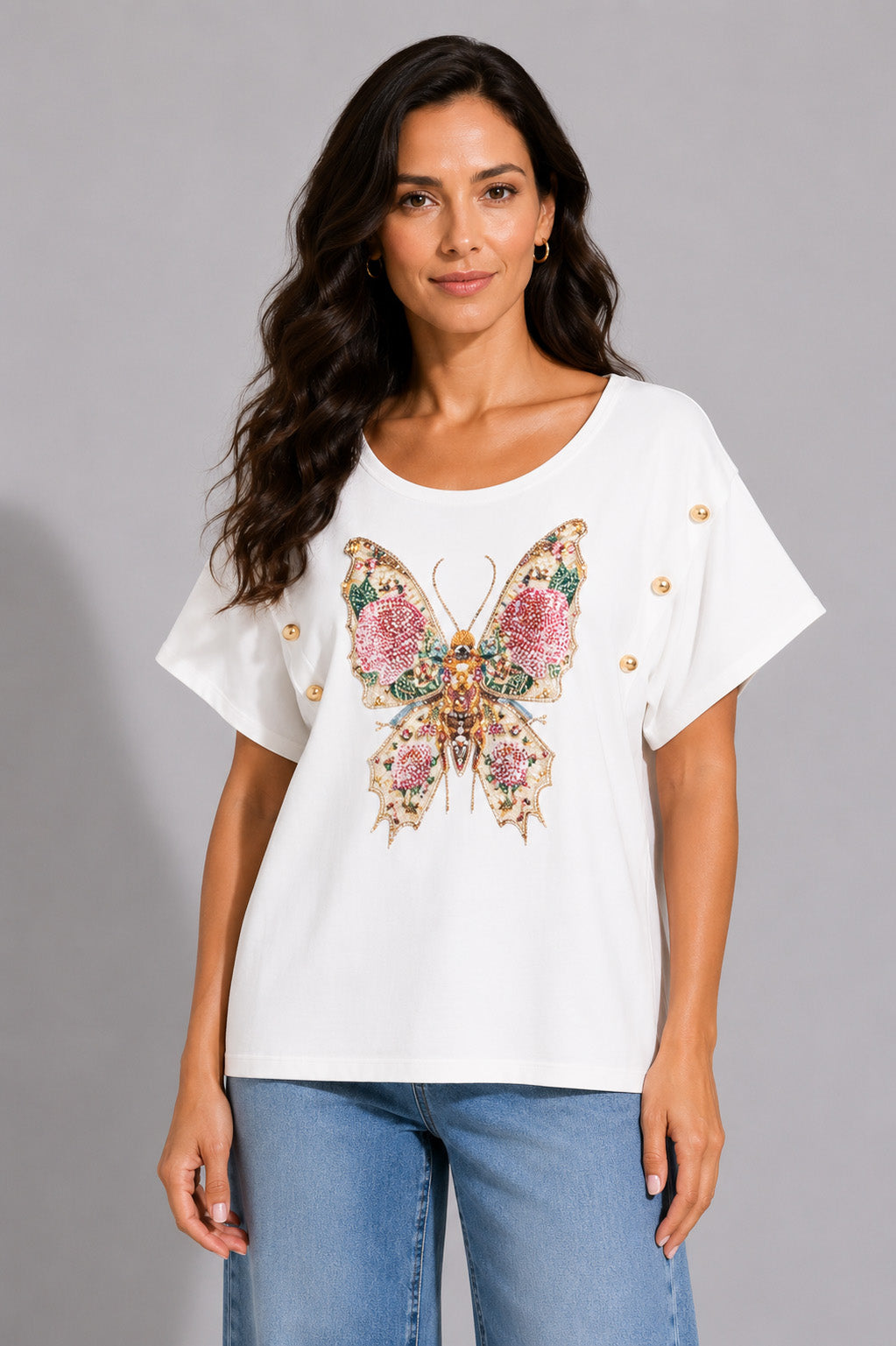 Λευκό γυναικείο T-shirt με διακοσμητική πεταλούδα από χάντρες και πέτρες και μεταλλικά κουμπιά στα μανίκια.