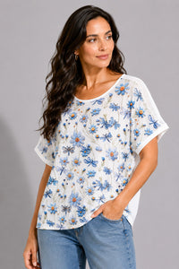 Λευκό γυναικείο T-shirt με γαλάζιο floral και dragonfly print, κοντό μανίκι και διάτρητες λεπτομέρειες στους ώμους.