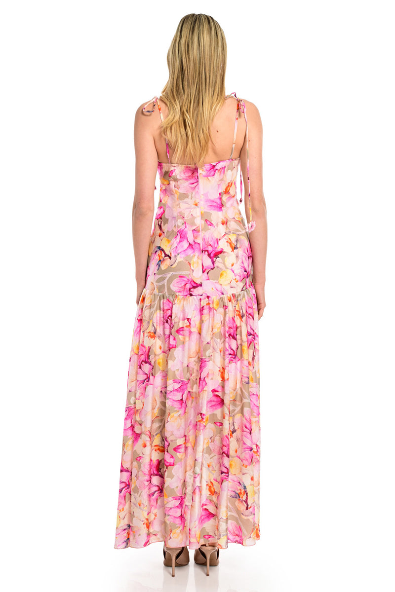 Maxi floral φόρεμα με ροζ εμπριμέ σχέδιο, σούρες στο μπούστο και ασύμμετρο τελείωμα.