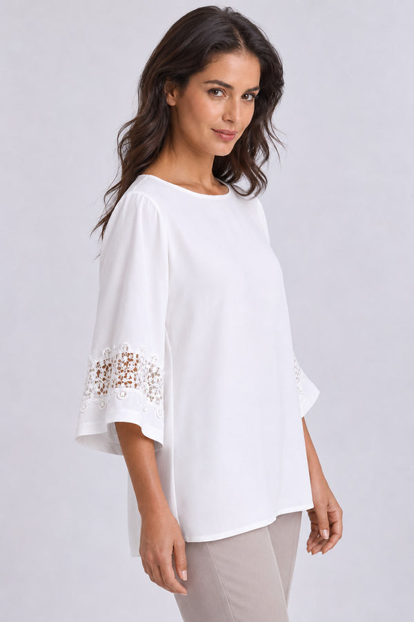 Γυναικεία off white μπλούζα με στρογγυλή λαιμόκοψη και δαντελένια λεπτομέρεια στα μανίκια.