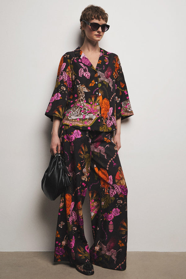 Γυναικείο wide leg παντελόνι με exotic tropical print σε μαύρη βάση και φούξια λεπτομέρειες