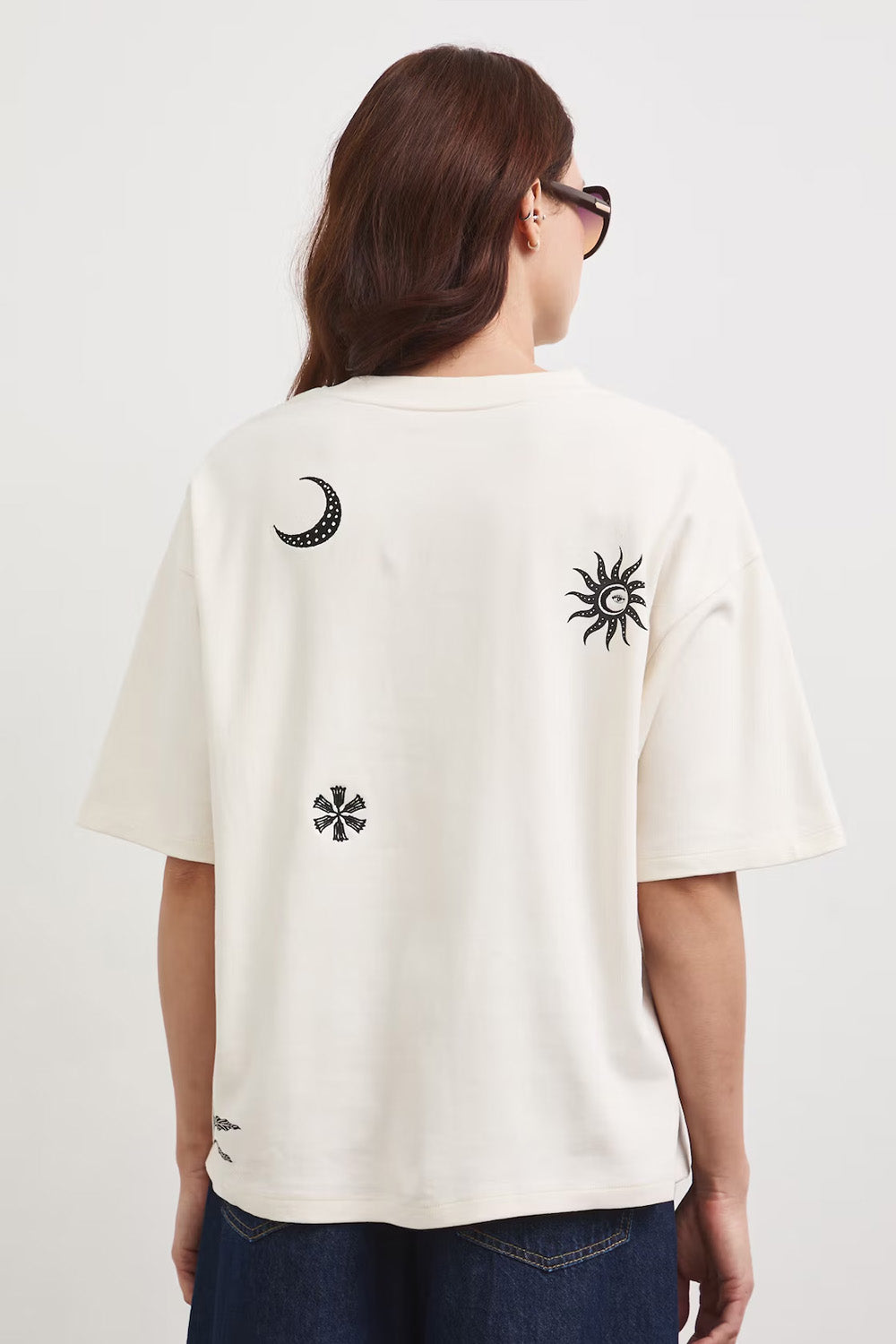 Oversize εκρού βαμβακερό t-shirt με minimal print σε μαύρες λεπτομέρειες και φαρδιά κοντά μανίκια