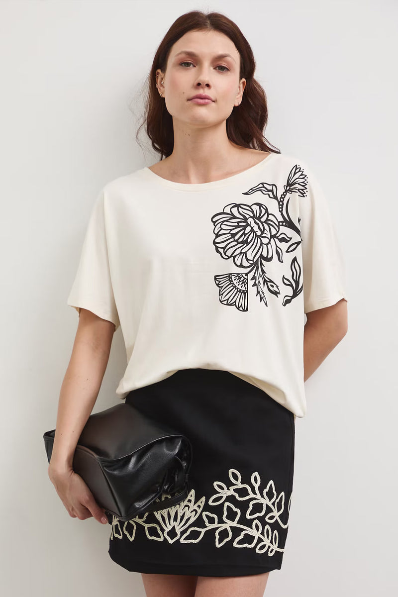 Γυναικείο εκρού t-shirt με floral print σε μαύρη αντίθεση και ανοιχτή πλάτη με λεπτομέρεια λωρίδας