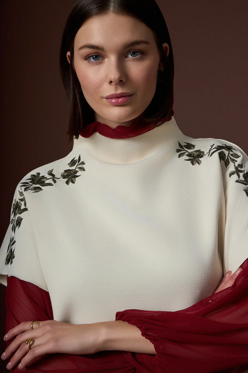 Αμάνικη εκρού γυναικεία μπλούζα με διακριτικές κεντημένες λεπτομέρειες στους ώμους, φορεμένη σε μοντέλο σε studio φωτογράφιση