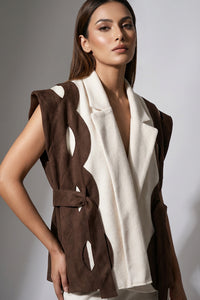 Αμάνικη διχρωμη ζακέτα εκρού καφέ με ζώνη στη μέση σε minimal εμφάνιση μοντέλου.