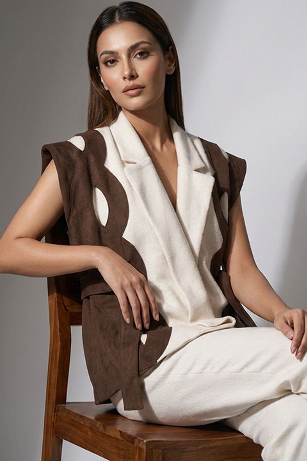 Αμάνικη διχρωμη ζακέτα εκρού καφέ με ζώνη στη μέση σε minimal εμφάνιση μοντέλου.