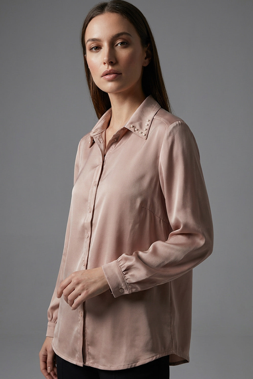 Μπεζ γυναικείο πουκάμισο με μεταλλικά τρουκς στον γιακά και μακρύ μανίκι, σε άνετη γραμμή.