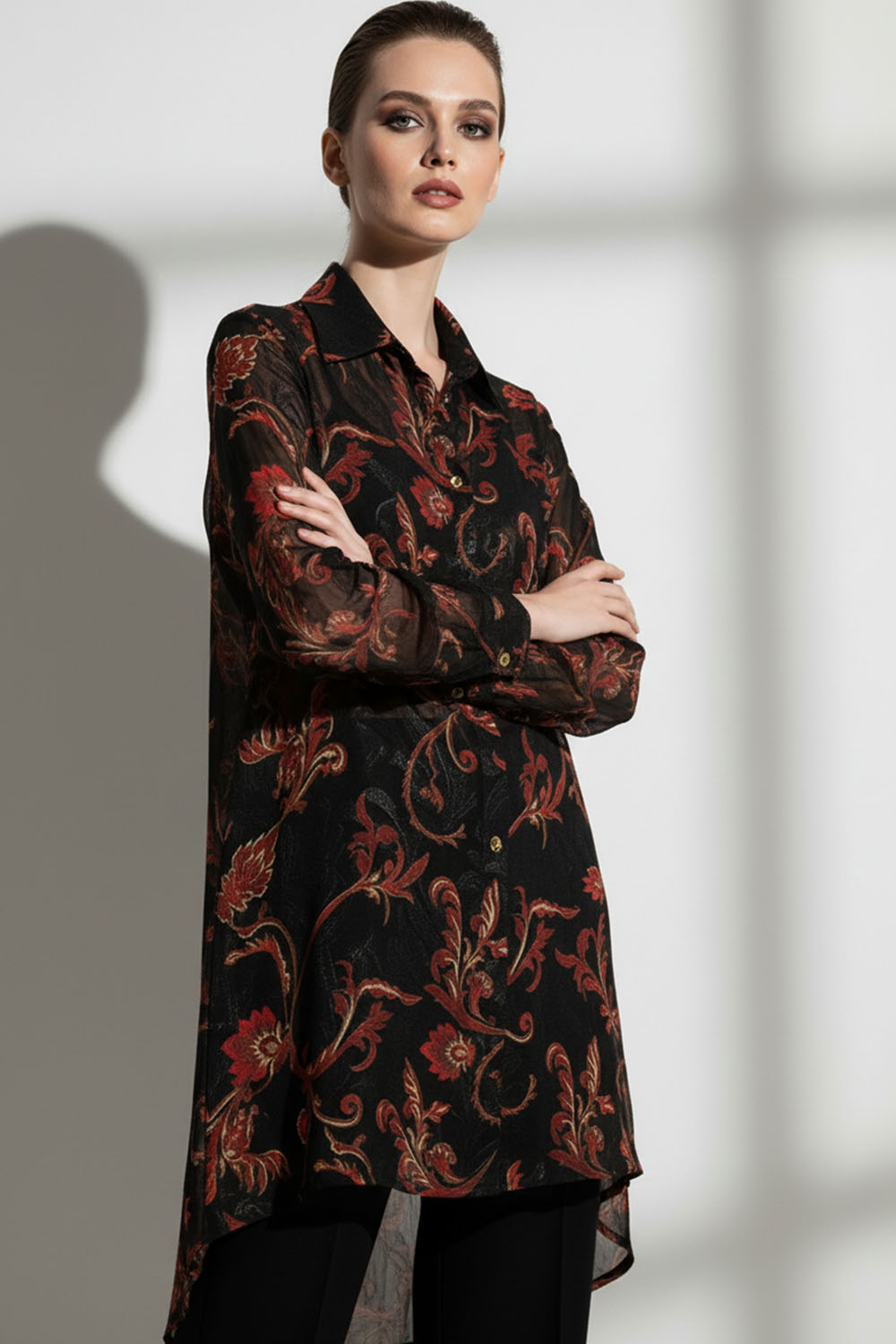 Μαύρο εμπριμέ πουκάμισο με κόκκινα και χρυσά μοτίβα, ημιδιάφανο και ασύμμετρο, με χρυσά κουμπιά.