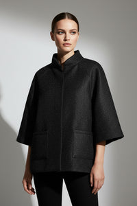 Μαύρο minimal μπουφάν με μανίκι 3/4 και όρθιο γιακά, φωτογραφημένο σε μοντέλο studio.