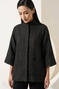 Μαύρο minimal μπουφάν με μανίκι 3/4 και όρθιο γιακά, φωτογραφημένο σε μοντέλο studio.