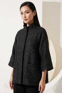 Μαύρο minimal μπουφάν με μανίκι 3/4 και όρθιο γιακά, φωτογραφημένο σε μοντέλο studio.