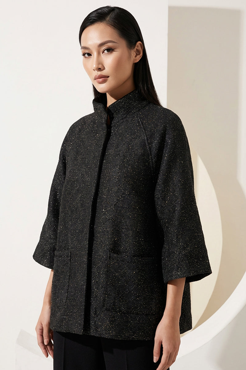 Μαύρο minimal μπουφάν με μανίκι 3/4 και όρθιο γιακά, φωτογραφημένο σε μοντέλο studio.