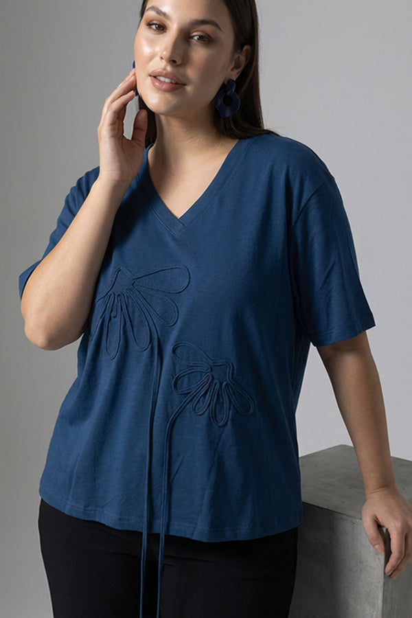 Μπλε oversized μπλούζα με V λαιμόκοψη και ανάγλυφα διακοσμητικά μοτίβα μπροστά.