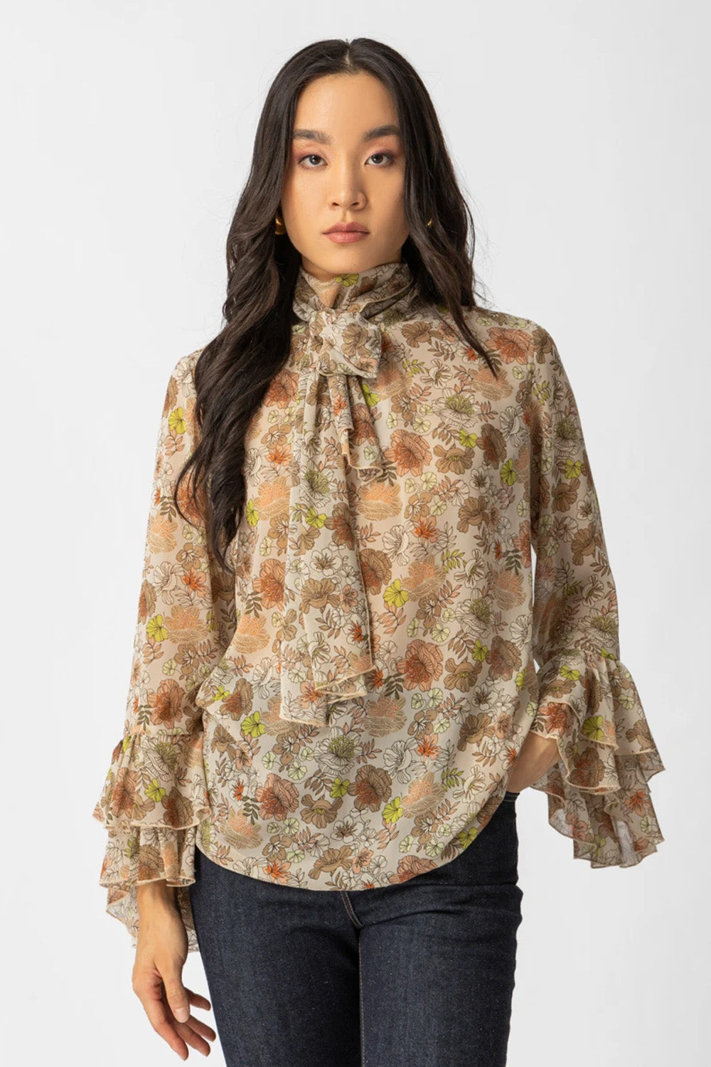 Εμπριμέ μπλούζα με διαφάνεια, φιόγκο στο λαιμό και μανίκια με βολάν σε αέρινη γραμμή.