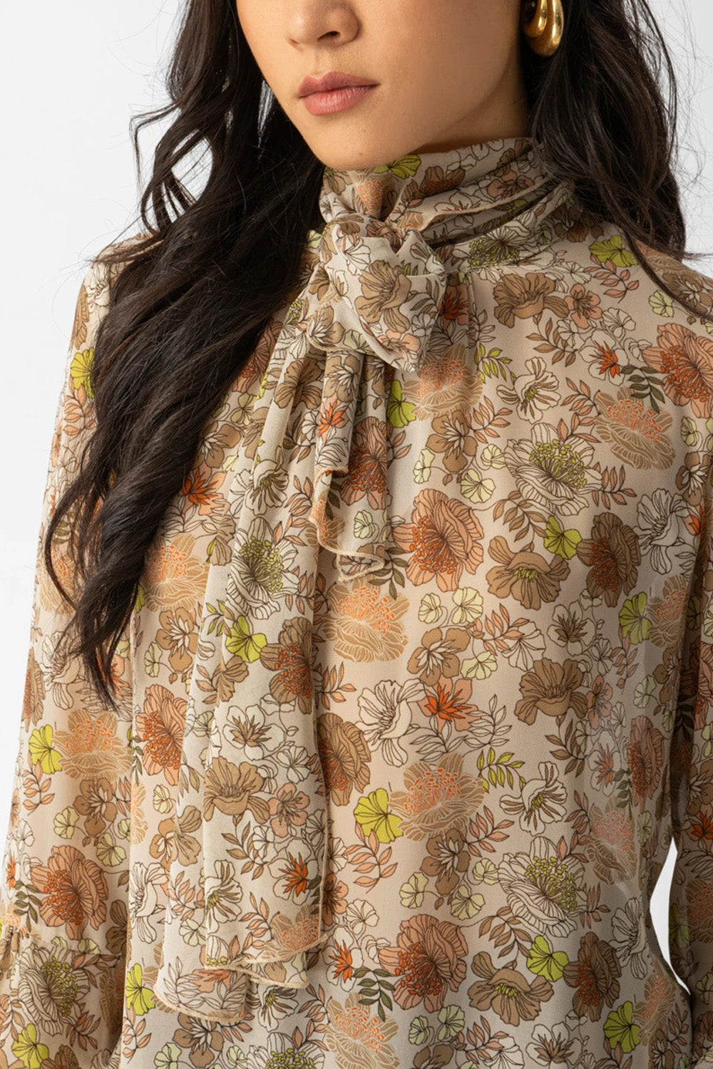 Εμπριμέ μπλούζα με διαφάνεια, φιόγκο στο λαιμό και μανίκια με βολάν σε αέρινη γραμμή.