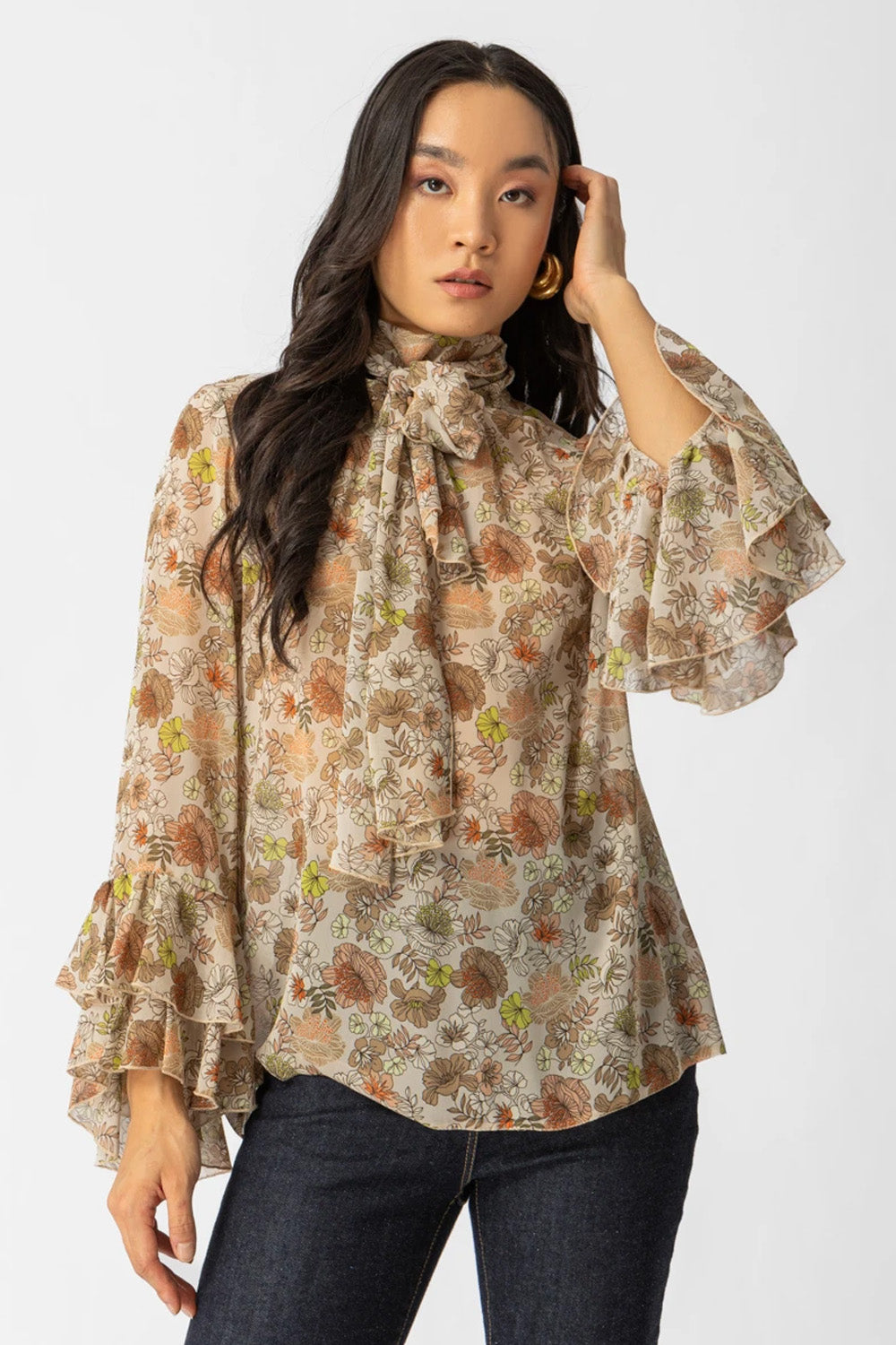 Εμπριμέ μπλούζα με διαφάνεια, φιόγκο στο λαιμό και μανίκια με βολάν σε αέρινη γραμμή.