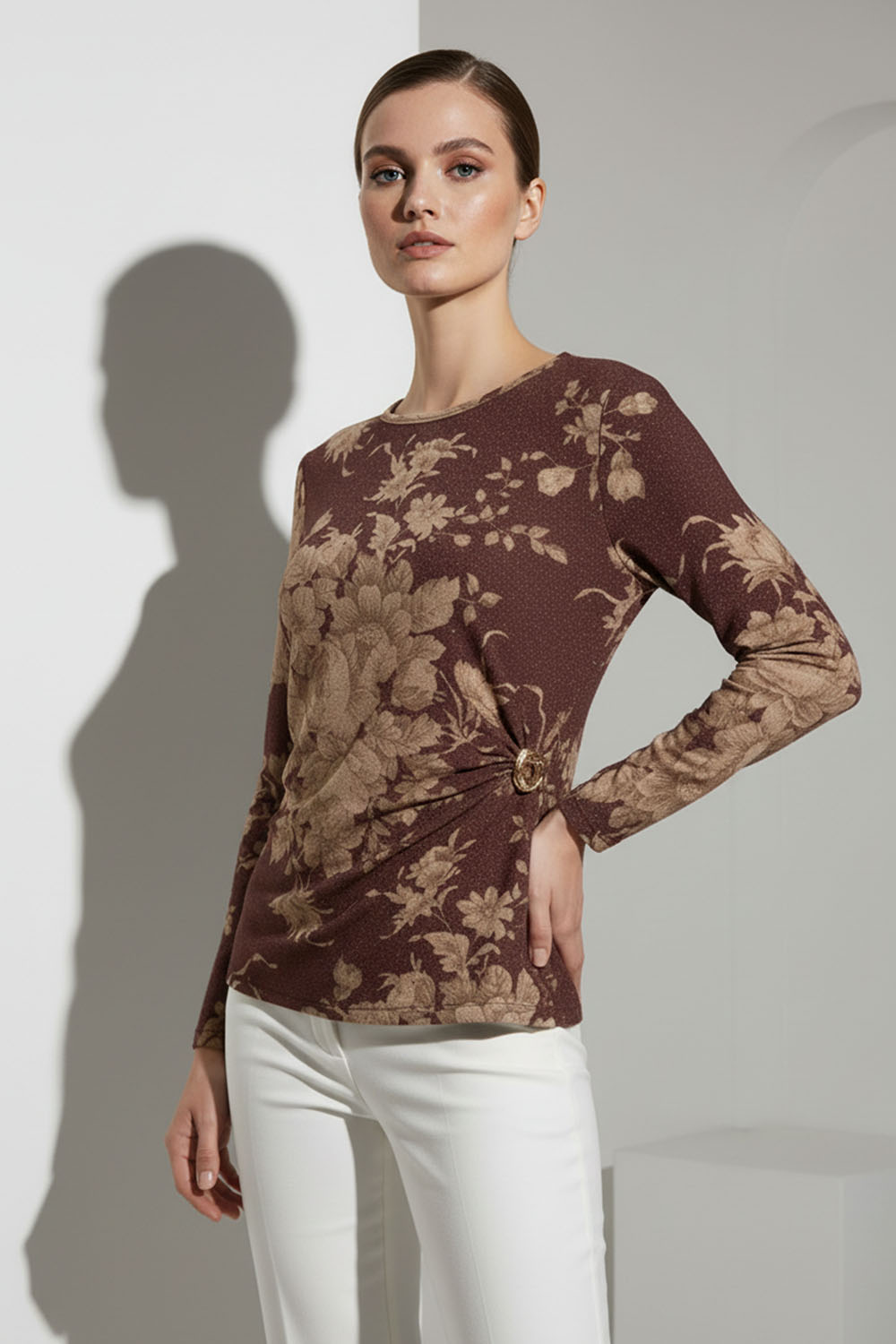 Μπλούζα καφέ με μπεζ floral μοτίβο και πλαϊνή αγκράφα, μακρυμάνικη, σε μοντέλο με λευκό παντελόνι.