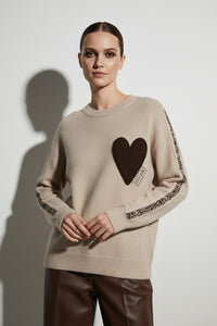 Μπεζ πλεκτή μπλούζα με καφέ ανάγλυφη καρδιά και διακοσμητική πλέξη στα μανίκια σε άνετη γραμμή.