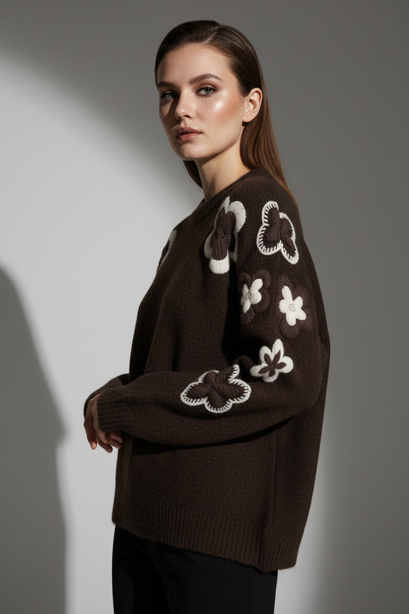 Πλεκτή καφέ μπλούζα με ανάγλυφα crochet λουλούδια σε μπεζ και εκρού αποχρώσεις στα μανίκια και στους ώμους.