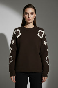 Πλεκτή καφέ μπλούζα με ανάγλυφα crochet λουλούδια σε μπεζ και εκρού αποχρώσεις στα μανίκια και στους ώμους.