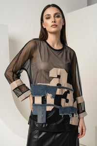 Μπλούζα με patch λεπτομέρειες στο μπροστινό μέρος και διάφανα μανίκια, φορεμένη από μοντέλο.