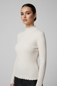 Εκρού πλεκτή ριπ μπλούζα με ψηλό λαιμό και κυματιστά τελειώματα σε εφαρμοστή γραμμή.