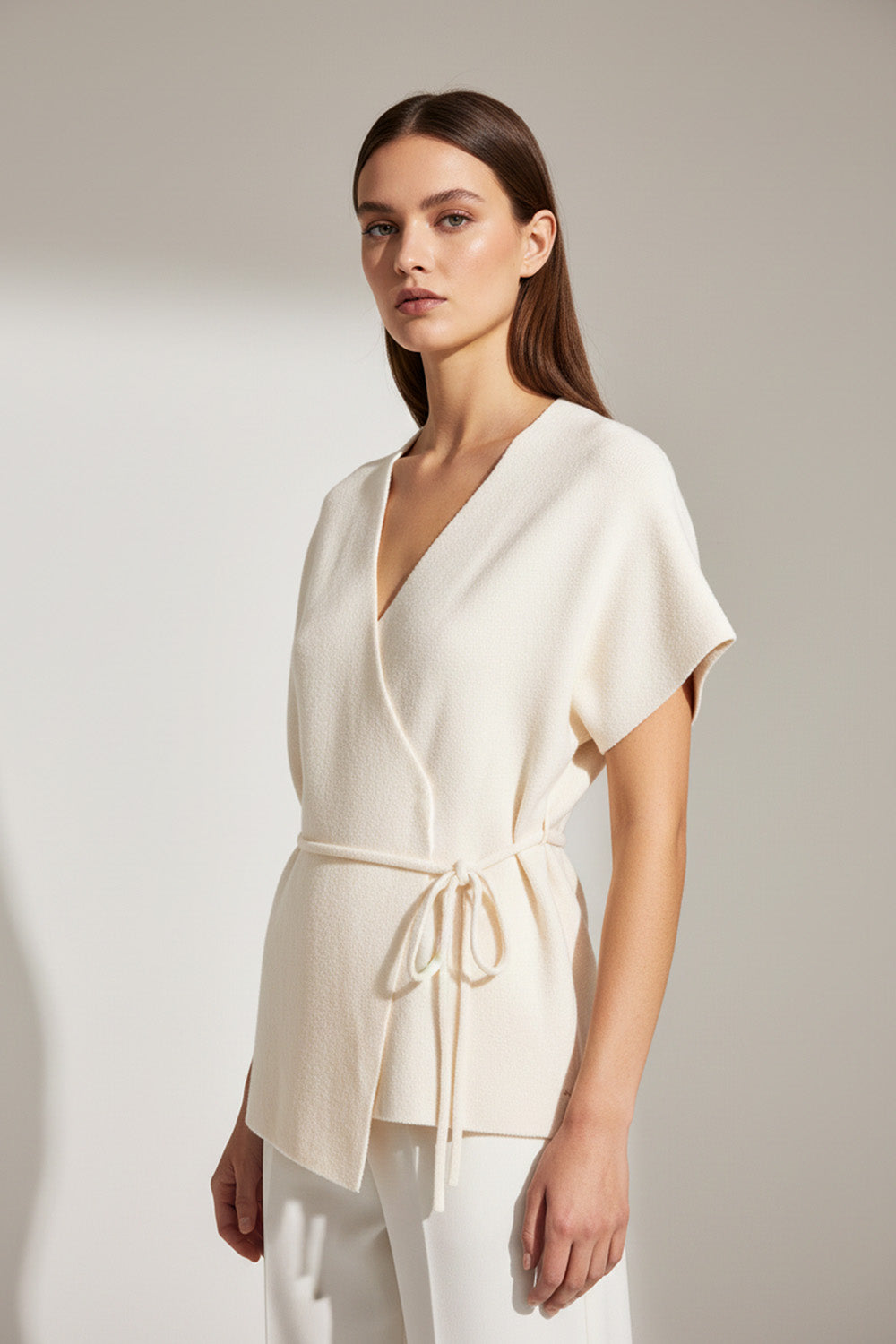 Εκρού μπλούζα-ζακέτα με σταυρωτό σχέδιο, V λαιμόκοψη και ζώνη στη μέση σε άνετη γραμμή.