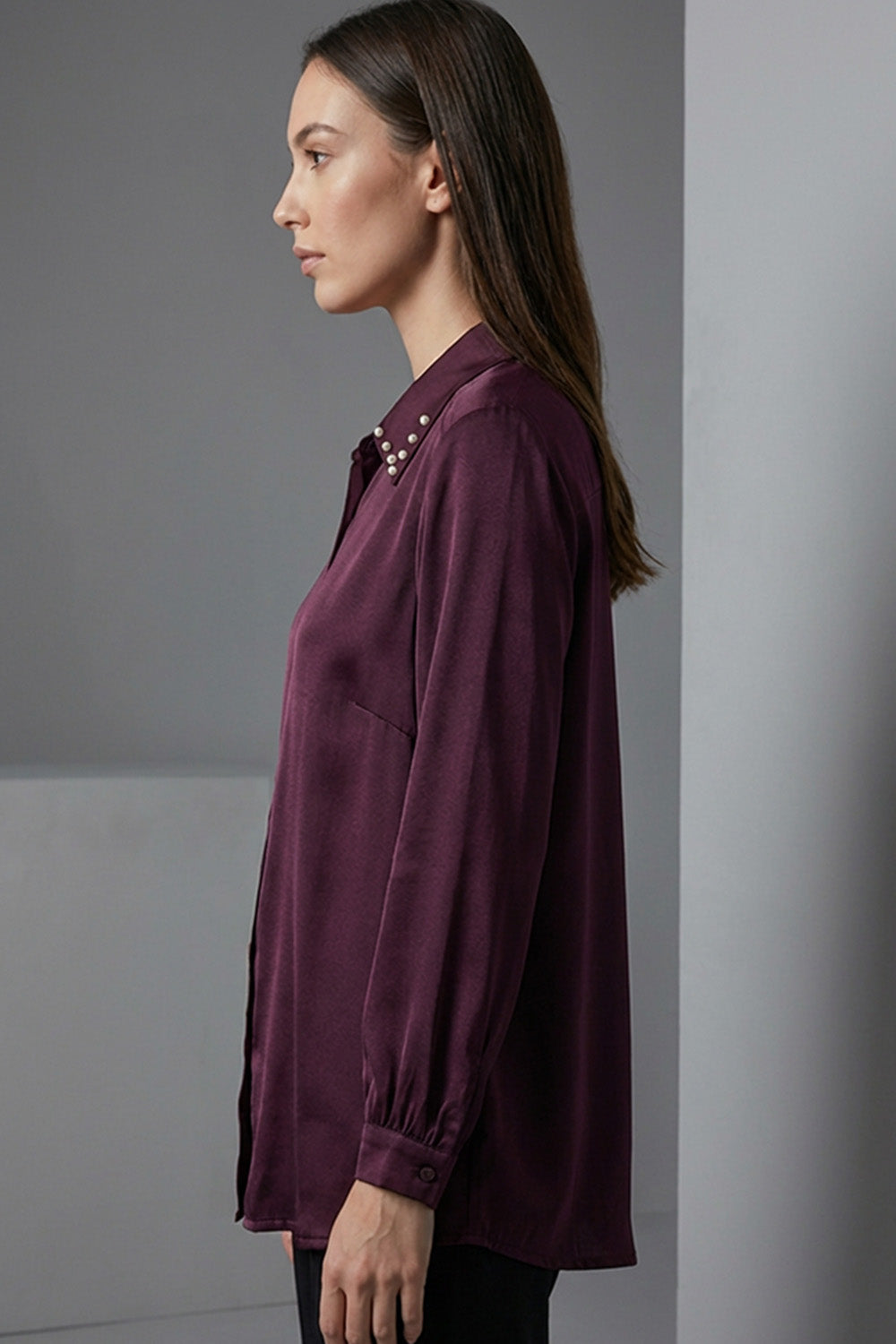 Μπορντό γυναικείο πουκάμισο με μεταλλικά τρουκς στον γιακά και μακρύ μανίκι, σε άνετη γραμμή.