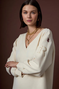 Εκρού γυναικείο μπλουζοφόρεμα με V λαιμό και μακριά μανίκια, φορεμένο σε μοντέλο σε studio φωτογράφιση