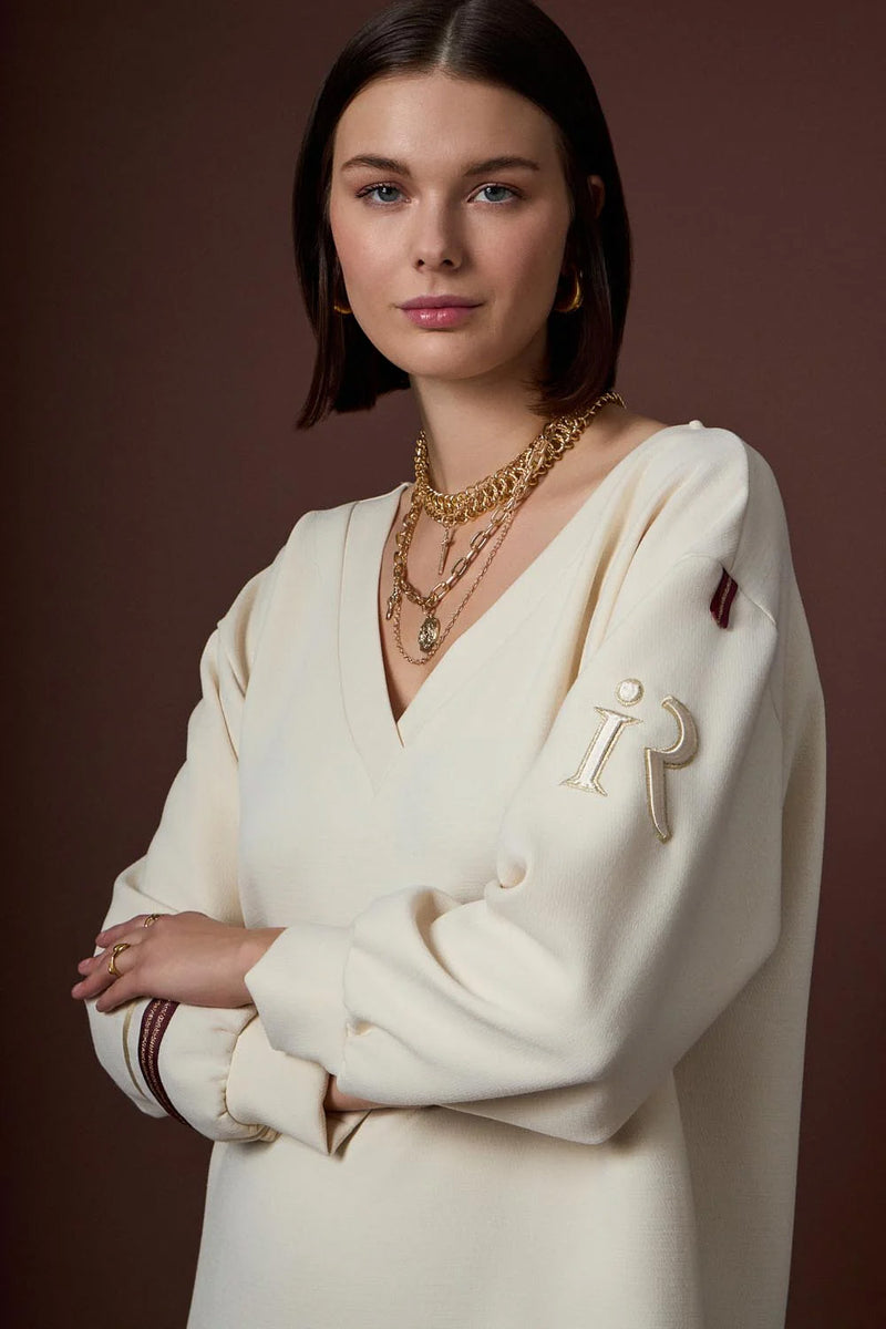 Εκρού γυναικείο μπλουζοφόρεμα με V λαιμό και μακριά μανίκια, φορεμένο σε μοντέλο σε studio φωτογράφιση