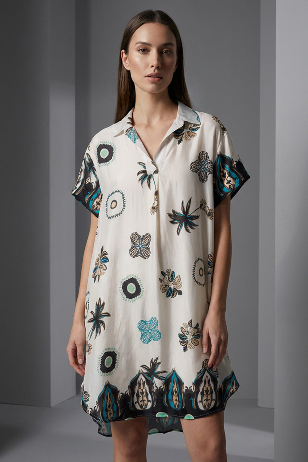 Εκρού εμπριμέ σεμιζιέ φόρεμα με κοντό μανίκι και μοτίβα σε πετρόλ και μαύρο, φωτογραφημένο σε studio με μοντέλο