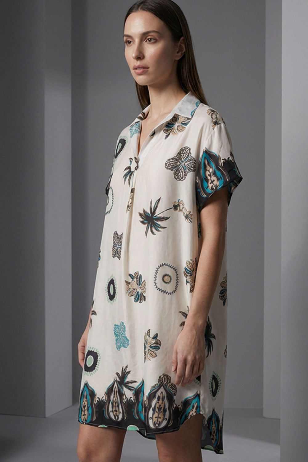 Εκρού εμπριμέ σεμιζιέ φόρεμα με κοντό μανίκι και μοτίβα σε πετρόλ και μαύρο, φωτογραφημένο σε studio με μοντέλο