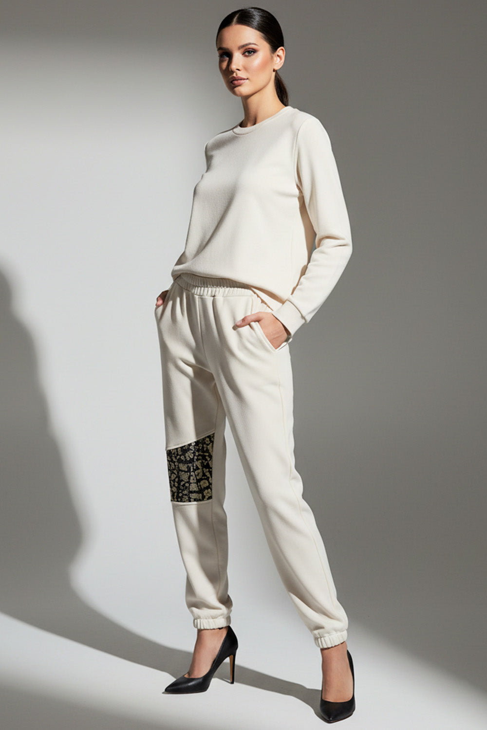 Εκρού φόρμα jogger με λάστιχο και διακοσμητικό μοτίβο στο μπατζάκι σε στούντιο φωτογράφιση.