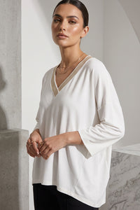 Εκρού γυναικεία μπλούζα με V λαιμόκοψη, 3/4 μανίκι και διακοσμητικό print στην πλάτη.