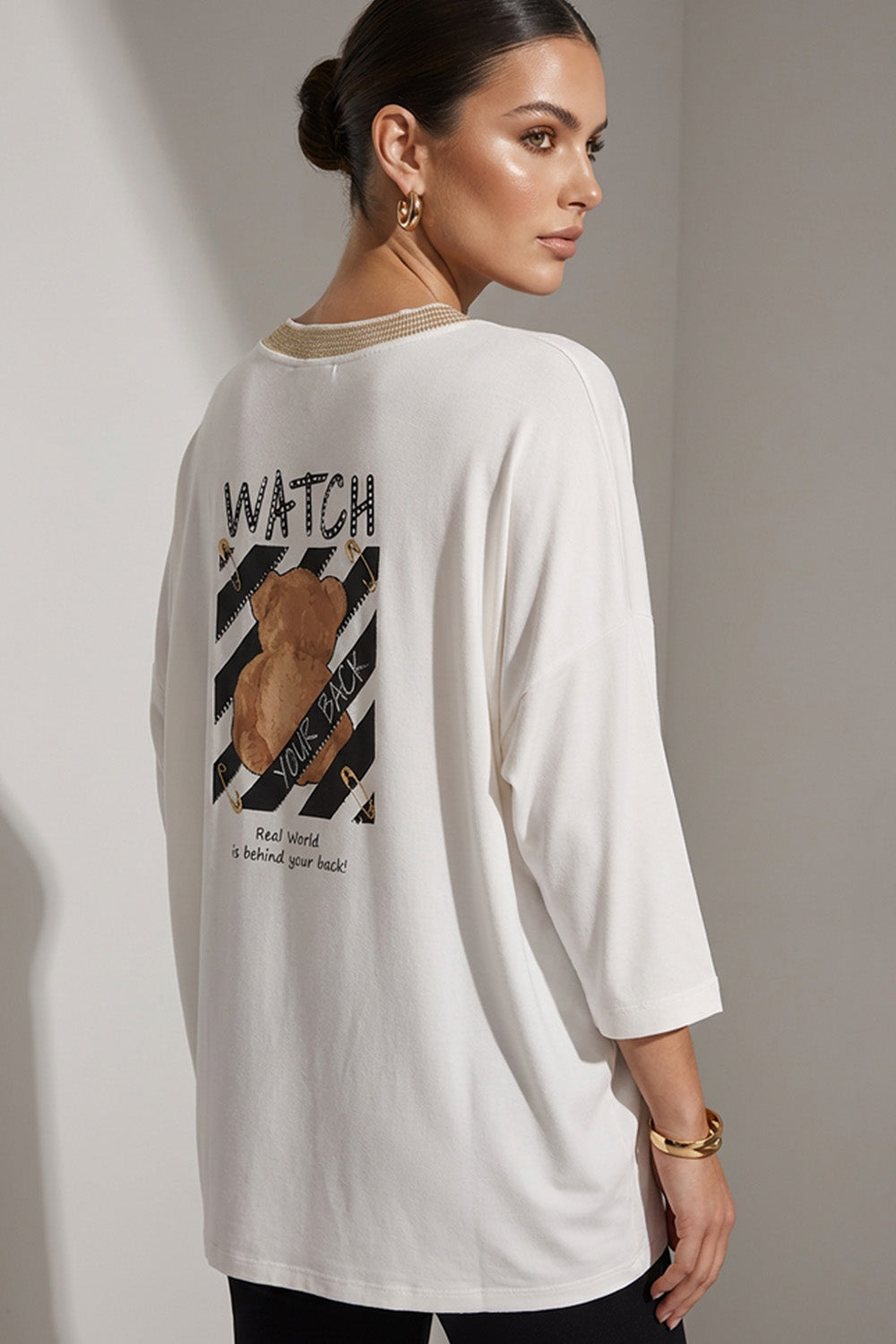 Εκρού γυναικεία μπλούζα με V λαιμόκοψη, 3/4 μανίκι και διακοσμητικό print στην πλάτη.