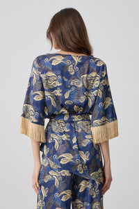 Εμπριμέ ασύμμετρη μπλούζα σε μπλε με χρυσό σχέδιο και κρόσσια στα μανίκια με δέσιμο στη μέση