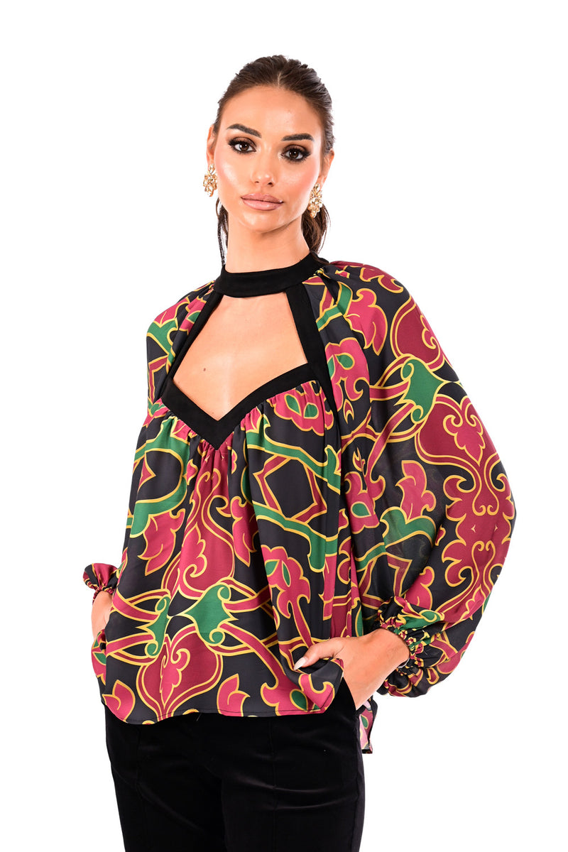 Εμπριμέ γυναικεία μπλούζα με cut-out λαιμόκοψη, μαύρες λεπτομέρειες και ανοιχτή πλάτη με δεσίματα, φορεμένη από μοντέλο.