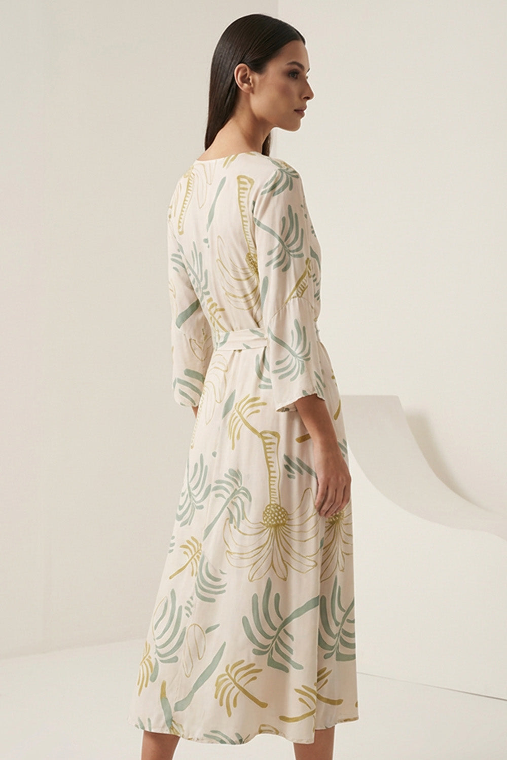 Εμπριμέ κρουαζέ φόρεμα σε εκρού βάση με πράσινα μοτίβα, V λαιμόκοψη, ζώνη στη μέση και midi μήκος.