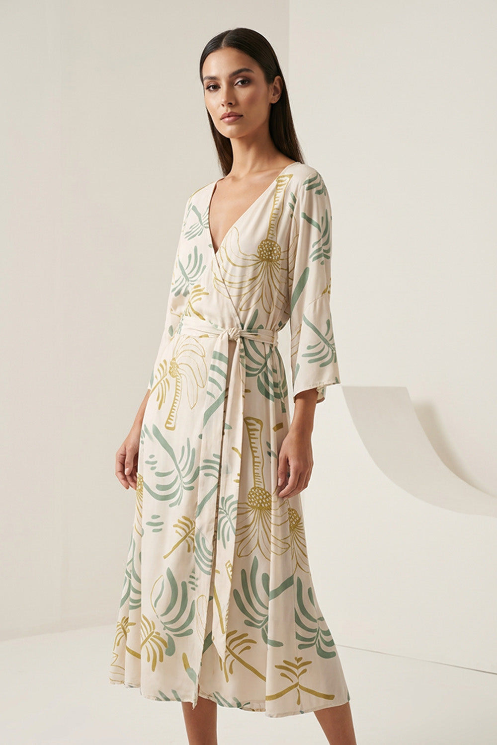 Εμπριμέ κρουαζέ φόρεμα σε εκρού βάση με πράσινα μοτίβα, V λαιμόκοψη, ζώνη στη μέση και midi μήκος.
