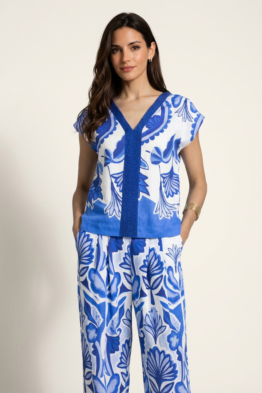 Εμπριμέ μπλε και λευκό τοπ με V λαιμόκοψη και διακοσμητική τρέσα μπροστά και πίσω, σε συνδυασμό με παντελόνι σετ