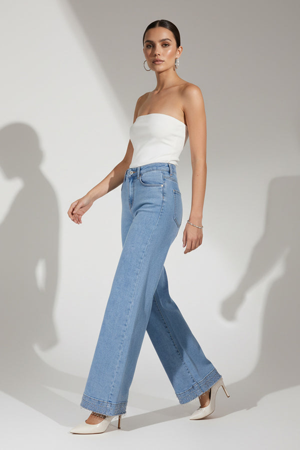 Γαλάζια ψηλόμεση denim παντελόνα με φαρδύ πόδι και διακοσμητικά στρας στο τελείωμα.