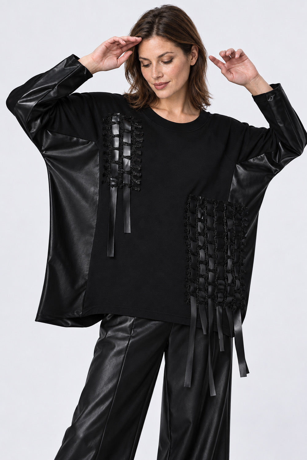 Γυναικεία μαύρη oversized μπλούζα με μανίκια σε όψη δέρματος και διακοσμητικές κορδέλες