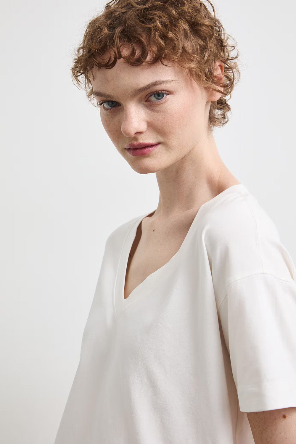 Γυναικεία Off White μπλούζα V-neck με κοντό μανίκι και πολύχρωμο floral print στην πλάτη.